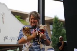 Một người chủ tự hào kể về ba chú cún của mình tại sự kiện. (Ảnh: Hồng Minh/TTXVN)