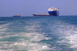 Tàu chở hàng (phải), bị lực lượng Houthi bắt giữ, trên đường về cảng tỉnh Hodeida (Yemen), ngoài khơi Biển Đỏ, ngày 22/11/2023. (Ảnh: AFP/TTXVN)