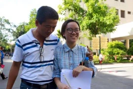 Thí sinh vui vẻ trao đổi thông tin với người thân sau giờ thi. (Ảnh: Lê Minh Sơn/Vietnam+)