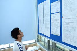 Thí sinh xem thông tin để làm thủ tục rút hồ sơ. (Ảnh: Lê Minh Sơn/Vietnam+)