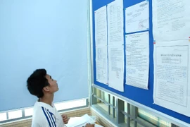 Thí sinh xem thông tin để làm thủ tục rút hồ sơ. (Ảnh: Lê Minh Sơn/Vietnam+)