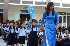 Cô và trò Trường Tiểu học Bạch Đằng, Thành phố Hồ Chí Minh, trong lễ khánh thành trường và khai giảng năm học mới 2015-2016. (Ảnh: Phuong Vy/TTXVN)