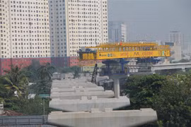 Lao lắp các đốt dầm đoạn trên cao tuyến metro số 1. (Ảnh: Trần Xuân Tình/TTXVN)
