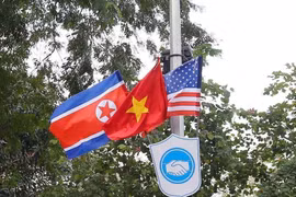 Cờ Mỹ, cờ Triều Tiên và cờ Việt Nam, bên dưới là biểu tượng hai bàn tay bắt chặt vào nhau thể hiện tinh thần của cuộc gặp lớn được treo trên các tuyến phố xung quanh hồ Hoàn Kiếm. (Ảnh: Danh Lam/TTXVN)