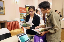 Doanh nghiệp Hội An giới thiệu với khách hàng các gói sản phẩm, dịch vụ tour. (Ảnh: Mỹ Phương/TTXVN)