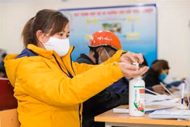 Người dân nghiêm túc thực hiện đeo khẩu trang và sát khuẩn theo quy định. (Ảnh: Bích Huệ/TTXVN)