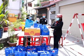 Liên đoàn Lao động quận Gò Vấp tặng quà người dân tại các khu cách ly. (Ảnh: Thanh Vũ/TTXVN)