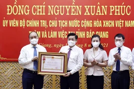 Chủ tịch nước Nguyễn Xuân Phúc trao Huân chương Lao động hạng Ba cho Đảng bộ, chính quyền và nhân dân tỉnh Bắc Giang. (Ảnh: Thống Nhất/TTXVN)