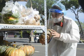 Chiến sỹ công an kiểm tra các mặt hàng tại điểm bán hàng đường 2-9 (quận Hải Châu). (Ảnh: Văn Dũng/TTXVN)