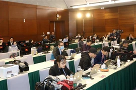 Phóng viên báo chí quốc tế tác nghiệp tại Trung tâm Báo chí Đại hội XIII của Đảng. (Ảnh: TTXVN)