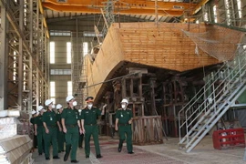 Trung tướng Ngô Minh Tiến cùng đoàn công tác kiểm tra xưởng đóng tàu gỗ tại Nhà máy X51. (Ảnh: Hồng Pha/TTXVN phát)