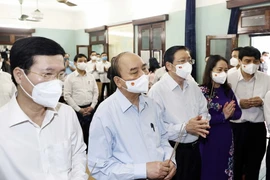 Chủ tịch nước Nguyễn Xuân Phúc và các thành viên trong đoàn thành kính dâng hoa, dâng hương tại Nhà 67. (Ảnh: Thống Nhất/TTXVN)