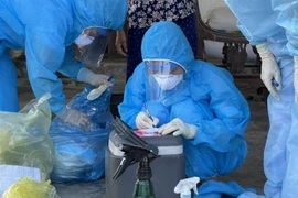 Cán bộ y tế ghi tên vào mẫu xét nghiệm. (Ảnh: Hoàng Ngà/TTXVN)