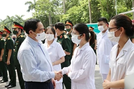 Thủ tướng Phạm Minh Chính động viên cán bộ y tế và lực lượng phòng, chống dịch. (Ảnh: Dương Giang/TTXVN)