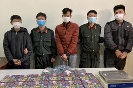 Các đối tượng cùng tang vật tại cơ quan công an. (Ảnh: TTXVN phát)
