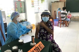 Tiêm vaccine cho người dân tại điểm tiêm ở thị trấn Cái Nhum (Mang Thít, Vĩnh Long). (Ảnh: Lê Thúy Hằng/TTXVN)