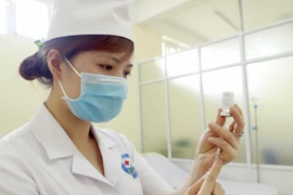 Chuẩn bị lấy vaccine phòng COVID-19 trước khi tiêm. (Ảnh: Hoàng Hùng/TTXVN)