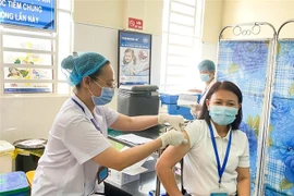 Tiêm vaccine cho những người làm trên tuyến đầu chống dịch ở Bình Dương. (Ảnh: TTXVN phát)