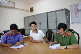 Đối tượng Vàng A Bông (giữa) tại cơ quan điều tra. (Ảnh: Thanh Hải/TTXVN)