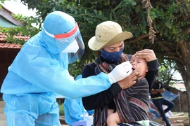 Lực lượng y tế lẫy mẫu xét nghiệm cho em bé người đồng bào dân tộc thiểu số buôn Ly, xã Ea Trol (Sông Hinh, Phú Yên). (Ảnh: Phạm Cường/TTXVN)