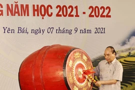 Chủ tịch nước Nguyễn Xuân Phúc đánh trống khai giảng năm học mới. (Ảnh: Thống Nhất/TTXVN)