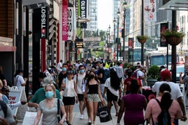 Người dân di chuyển trên một tuyến phố mua sắm ở New York, Mỹ ngày 7/6/2021. (Ảnh: AFP/TTXVN)