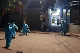 Lực lượng chức năng phun khử khuẩn khu vực bệnh nhân COVID-19 sinh sống. (Ảnh: TTXVN phát)