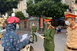 Công an huyện Đông Anh kiểm tra giấy đi đường của người dân trên đường Cao Lỗ, trung tâm thị trấn Đông Anh - nơi tập trung các cơ quan hành chính nhà nước. (Ảnh: Nguyễn Văn Cảnh/TTXVN)