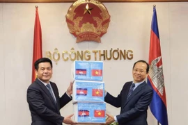 Bộ trưởng Công Thương Nguyễn Hồng Diên trao tượng trưng 20.000 khẩu trang phòng, chống dịch COVID-19 cho Đại sứ Campuchia. (Ảnh: Trần Việt/TTXVN)