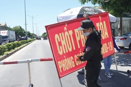 Cảnh sát cơ động làm nhiệm vụ trực chốt tại Quốc lộ 46 đoạn tiếp giáp giữa xã Hưng Chính (thành phố Vinh) và Khu công nghiệp VSIP (huyện Hưng Nguyên). (Ảnh: Bích Huệ/TTXVN)