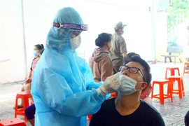 Cán bộ y tế lấy mẫu xét nghiệm SARS-CoV-2. (Ảnh: Tá Chuyên/TTXVN)
