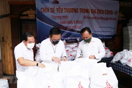 Ông Phùng Công Dũng, Chủ nhiệm Ủy ban về người Việt Nam ở nước ngoài Thành phố Hồ Chí Minh (ngoài cùng bên phải), ông Lê Bá Linh, kiều bào Thái Lan, Chủ tịch Hội đồng quản trị Công ty Cổ phần Pacific Foods (giữa) kiểm tra các phần quà cho người dân nghèo 