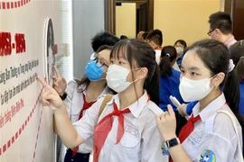 Các em đội viên tìm hiểu thông tin về cuộc đời và sự nghiệp của Chủ tịch Hồ Chí Minh. (Ảnh: Hồng Giang/TTXVN)