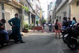 Lực lượng chức năng lập rào chắn khu vực cách ly tạm thời là một phần hẻm 359. (Ảnh: Thanh Vũ/TTXVN)