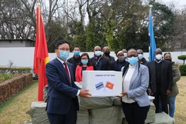 Đại sứ Hoàng Văn Lợi trao 50.000 khẩu trang cho Đại biện lâm thời Botswana tại Nam Phi Gaogane Tiny Mothobi trước sự chứng kiến của đại diện Đại sứ quán hai nước. (Ảnh: Hồng Minh/TTXVN)