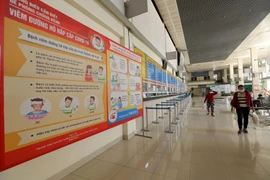 Các tấm bảng lớn cảnh báo về cơ chế lây nhiễm, tác hại và cách phòng, tránh SARS-CoV-2 được đặt tại các cửa ra vào Bến xe Gia Lâm. (Ảnh: Hoàng Hiếu/TTXVN)
