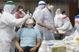 Lực lượng y tế lấy mẫu, xét nghiệm cho công nhân. (Ảnh: Thái Hùng/TTXVN)