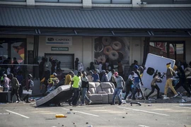 Các đối tượng cướp phá tại một cửa hàng ở Johannesburg, Nam Phi ngày 12/7/2021. (Ảnh: AFP/TTXVN)