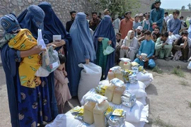 Phụ nữ nhận lương thực cứu trợ tại Jalalabad, Afghanistan, ngày 20/4/2021. (Ảnh: AFP/TTXVN)