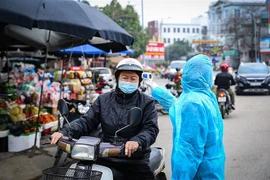 Điểm đo thân nhiệt cho người dân trước khi vào chợ. (Ảnh: Trọng Đạt/TTXVN)