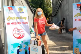 Những người nước ngoài trong khu phong tỏa tại phường Hàm Tiến, thành phố Phan Thiết vui mừng khi nhận quà hỗ trợ từ chương trình “san sẻ yêu thương với người nước ngoài” của Tỉnh đoàn Bình Thuận. Ảnh: Nguyễn Thanh -TTXVN