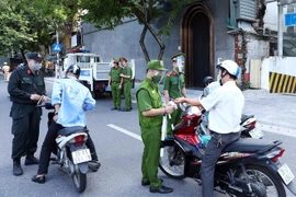  Lực lượng Công an Hà Nội kiểm tra giấy tờ của người tham gia giao thông tại chốt liên ngành tuyến phố Trần Quang Khải (quận Hoàn Kiếm). (Ảnh: Phạm Kiên/TTXVN)