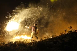 Người biểu tình Palestine ném chất cháy về phía binh sĩ Israel tại khu vực biên giới Gaza và Israel, ngày 15/6/2021. (Ảnh: AFP/TTXVN)