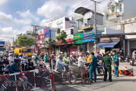 Lực lượng chức năng tại chốt kiểm soát cầu Chợ Cầu hướng dẫn người dân khai báo y tế, cũng như hướng dẫn lưu thông theo quy định. (Ảnh: TTXVN phát)