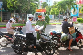 Lực lượng chức năng trên địa bàn thành phố Bạc Liêu (tỉnh Bạc Liêu) kiểm tra giấy đi đường của người tham gia giao thông. (Ảnh: Chanh Đa/TTXVN)