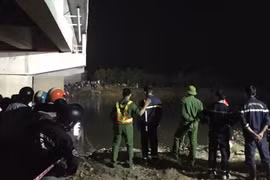 Lực lượng chức năng tìm kiếm nam học sinh bị rơi xuống sông. (Nguồn: Lao Động)