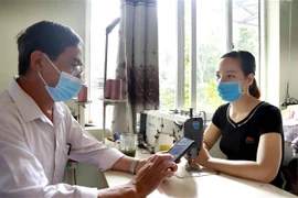 Điều tra viên thu thập thông tin, phỏng vấn một số chủ cơ sở sản xuất kinh doanh. (Ảnh: Hoàng Hùng/TTXVN)