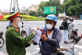 Lực lượng chức năng hỗ trợ người dân thực hiện khai báo thông tin di biến động trên đường Điện Biên Phủ, quận Bình Thạnh, Thành phố Hồ Chí Minh. (Ảnh: Thanh Vũ/TTXVN)