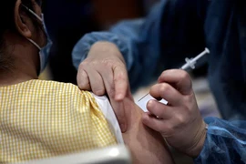 Nhân viên y tế tiêm vaccine ngừa COVID-19 của Pfizer-BioNTech cho người dân tại Paris, Pháp. (Ảnh: AFP/TTXVN)