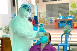 Lực lượng y tế xét nghiệm sàng lọc COVID-19 cho người dân. (Nguồn: TTXVN)